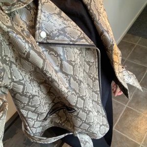 Skinnjacka - Fake skinnjacka med ormskinnsmönster. Storlek S men passar M också. Använd 1 gång och är verkligen som nyskick :) pris och frakt kan diskuteras :) 