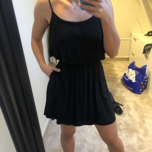 Söt svart klänning  - Väldigt fin svart sommarklänning med fickor och öppning i ryggen(se sista bilden). Stl XS. Frakt tillkommer! 