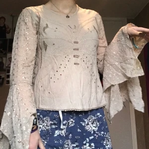 En beige långärmad tröja  - En beige långärmad tröja med Broderings detaljer i form av en fjäril på framsidan och snörning på sidorna. Kan mötas upp i Stockholm eller posta. Frakt 44kr. Meddela mig om eventuella frågor 