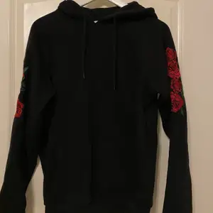 En simpel hoodie med små detaljer på ärmarna vilket gör den lige unik. Rosor broderat. Storlek S