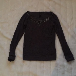  - Mörkgrå supersnygg tröja frän märket GUESS. Pärlor längs halsen upptill. Nypris 1099kr. Knappt använd. 