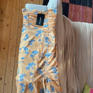 Klänning  - Säljer en jätte fin klänning som är gul med blåa blommor, lite sne skurning längst ner på klänningen. Storlek 36 på känningen och säljer pgr av att de inte är min stil. Köpt för 200kr säljer för 70 kronor. Buda gärna. Köparen står för frakten.❣️