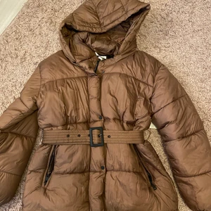Brun höst/vinterjacka - Jag Brun jacka med skärp i midjan, använd 3-4 gånger, varm!!