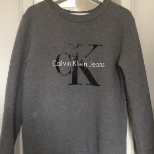 Calvin Klein tröja - Snygg tröja från Calvin Klein som tyvärr inte kommit så mycket till användning, känns som ny. Nypris 999kr säljes endast för 200kr! Frakt tillkommer