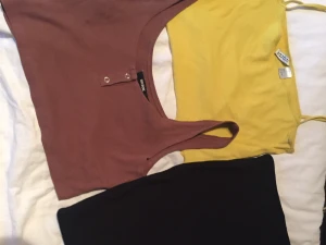 Toppar kjol - Två toppar och en kort svart tjock i bra skick kjolen är aldrig använd och topparna använd max 1 gång paket pris på allt 