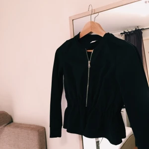  - Svart kofta i peplummodell med silvrig dragkedja, 50% bomull och 50% polyester. Köpt på Gina Tricot och aldrig använd - tyvärr för liten för mig. Frakt inkluderad i priset