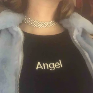  - Söt topp m ordet angel på och ett par vingar på armen. Frakten ingår ej