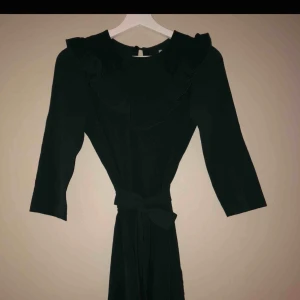  - Super fin mörkgrön klänning med volang vid halsen och band i midjan! Oanvänd 