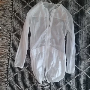 Jacka - En transperant jacka i superfint skick bortsett från snörena längst ner som är lite smutsiga, går säkert bort i tvätten. Använd en gång. Storlek XS.