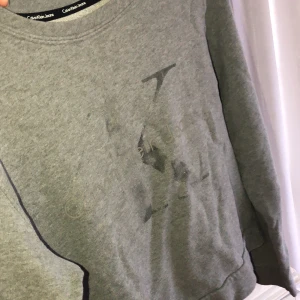 Calvin Klein Jeans sweatshirt i st:S - En Calvin Klein Jeans sweatshirt som är grå, med ett diskret tryck på framsidan. Den är köpt från affären Pondus. Säljer för 89kr, köparen står för frakten 💗 