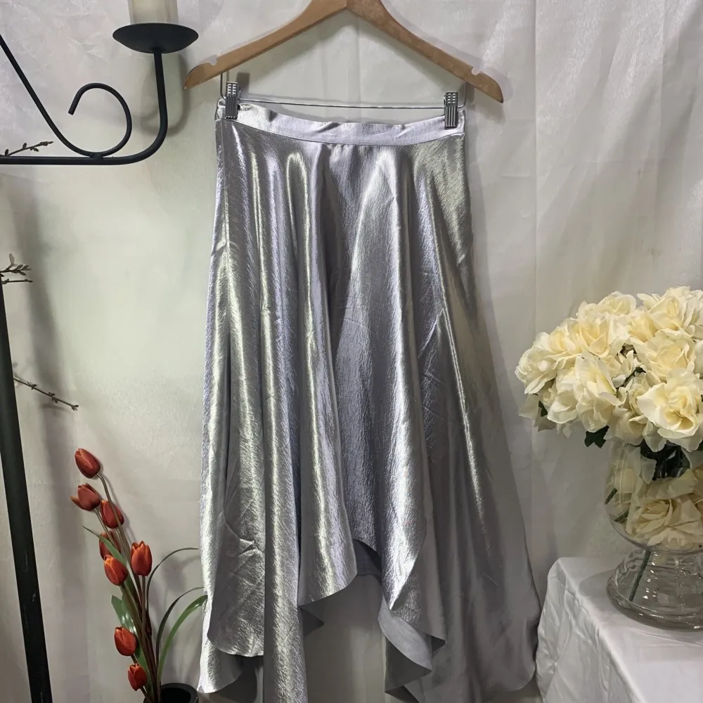 Jättefin kjol från H&M i silver! Perfekt till jul eller nyår! 🤩🌟 storkek S men sitter mer som en XS. Den är lite nopprig precis uppe vid midjan (se bild 3) därav det låga priset🌟. Kjolar.