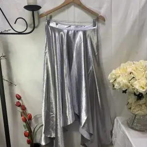 Jättefin kjol från H&M i silver! Perfekt till jul eller nyår! 🤩🌟 storkek S men sitter mer som en XS. Den är lite nopprig precis uppe vid midjan (se bild 3) därav det låga priset🌟
