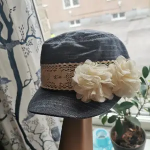 En söt liten och mjuk jeans keps med en vit-blommig detaljering vid sidan. Riktigt gullig och knappt använd. 