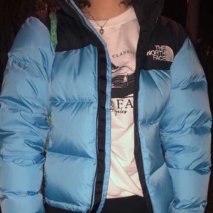 North Face jacka  - Ljusblå och svart pufferjacka, köpt i The North Face i oktober. Den är knappt använd och i storlek M (Dam). Buda i kommentarerna (minst 20kr)