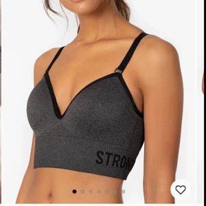 Stronger Nomad Anthracite Sport-bh - Jätteskön sport-bh från stronger. Som ny, använd fåtal gånger. Säljer på grund av att den är för stor och därmed inte sitter bra när jag tränar. Säljer även matchande tights (se bild tre)