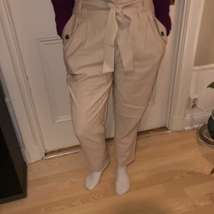 Beiga byxor  - Beiga byxor med snörning i midjan.