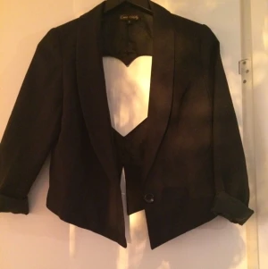  - Snygg kavaj med hjärtformad utskärning.
Köpt från Nelly för flera år sedan.
Kavajen är svart och i väldigt gott skick.
Frakt tillkommer. 
