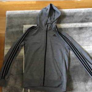 Adidas kofta  - En härlig adidas kofta som är grå. Väldigt bra och passar bra in på kroppen. Den är mysig och är varm. Den passar för både  S och M. Den är använd men den är i väldigt bra skick.