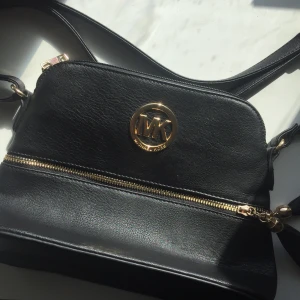 MK VÄSKA FEJK - En jättefin MK väska (fejk), köpt i Spanien för ungefär ett år sedan säljs för att jag aldrig har använt den. Från djur och rökfritt hem. Priset går att diskutera vid snabb affär. Den är i jättefint skick, då den aldrig använts. Många fack!