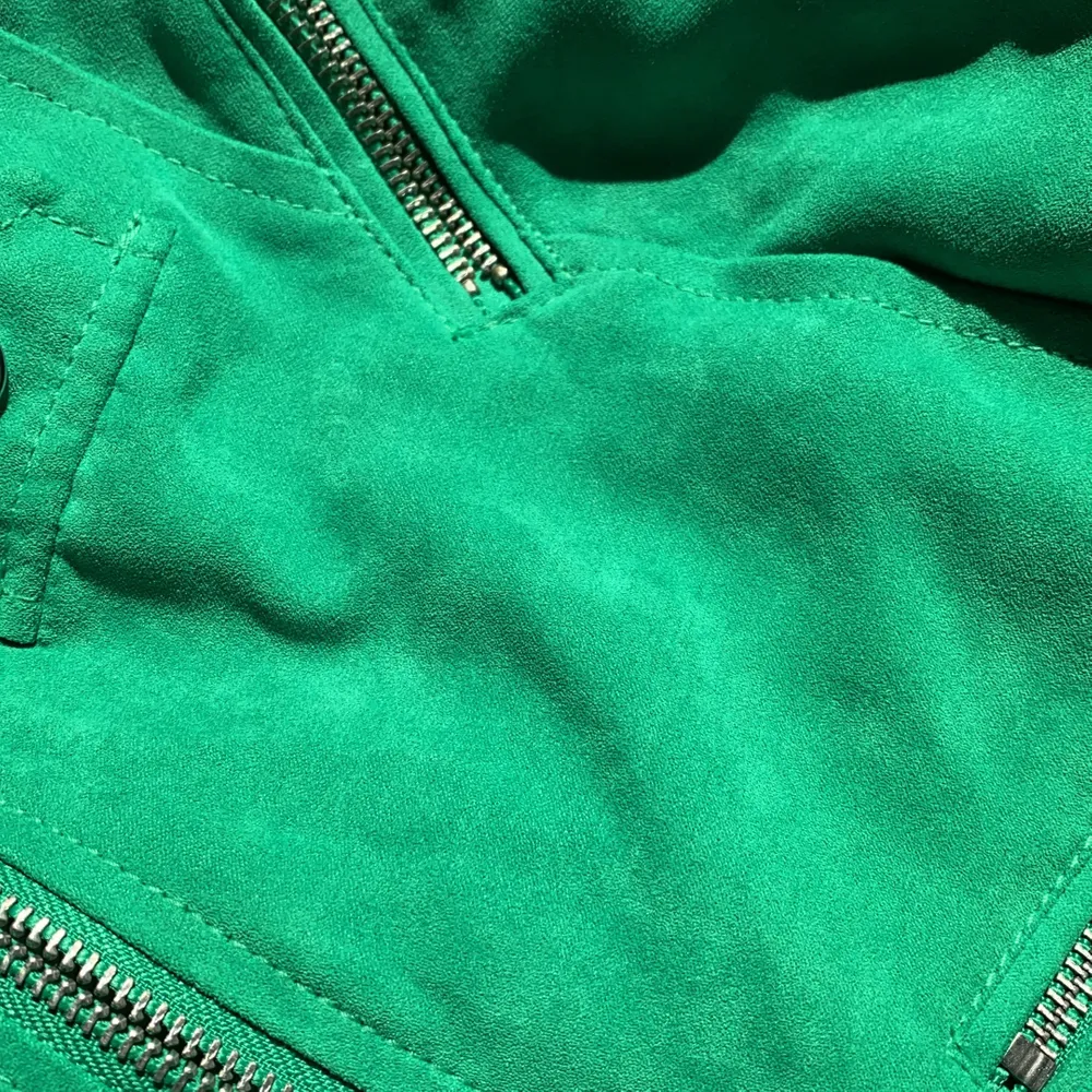 En grön jacka av mocka med silvriga detaljer. Sjukt snygg modell i storlek 36. Något tajt men i övrigt sitter den som en smäck. . Jackor.