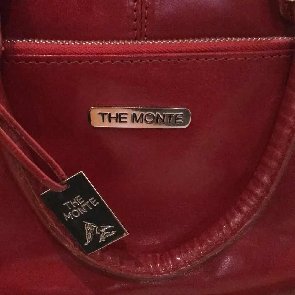 Äkta skinn Alex/handväska ”The Monte”, något år gammal, använd i gott skick. Mått D 12 cm, L 32 H 28 cm . Väskor.