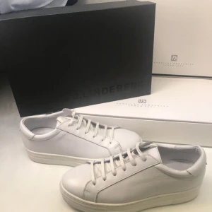  - 525kr inklusive spårbar frakt!! Fynda.  Ett par stilrena J.Lindeberg sneakers. Väldigt fin nu till våren och sommaren.   Nypris 1500kr köptes förra året på Åhléns i Nordstan. Använda ytterst lite då jag har andra liknande.   Vid frågor är det bara att höra av er! 