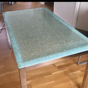 Ett matbord i glas med aluminium underrede. 80x140 cm.