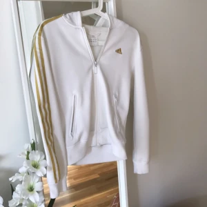  - Vit retro adidas vit och guld med luva. Passar både small och medium.  Kan skickas mot fraktkostnad.