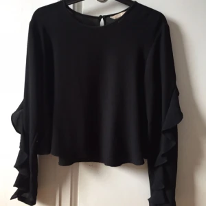  - Något croppad topp med volang på ärmarna 