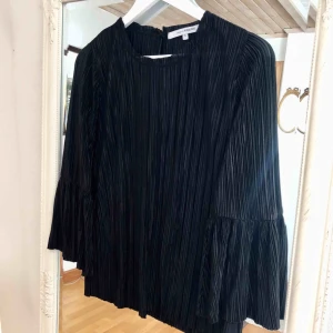  - En snygg svart blus med vida armar! Sparsamt använd. 