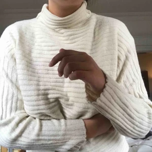  - Superskön stickad vit polotröja i ett räfflat mönster. 