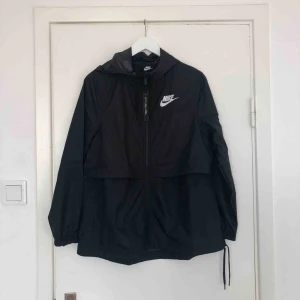  - Helt ny vårjacka från Nike, den går att justera så den blir tajtare. Säljer pga fel storlek, frakt betalar köparen och den är på 55kr. Det är en såkallad vindjacka och den har luva. 