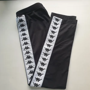  - Svarta Kappa byxor utan knappar i storlek XS köpta från Urban Outfiters. Endast använda 2-3 ggr pga fel storlek därför i mycket bra skick. Orginalpris 700 kr. Möts upp i Stockholm, betalning swish eller kontanter.  