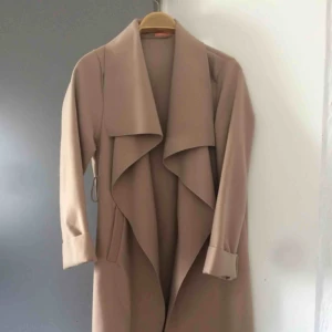  - En beige kappa, saknar skärp till den tyvärr. Knappt använd
