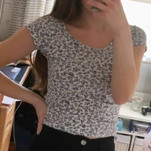 Blå vit söt somrig blommig crop top - Blå vit blommig topp/t-shirt i lite kortare modell! Fint skick!  Är stretchig så kan nog passa S också!  60kr + frakt.