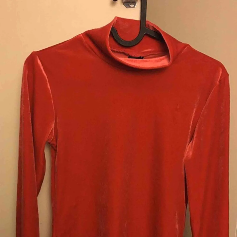 Röd skimrande polotröja i sammet strl XS från Gina Tricot. Aldrig använd, den är för liten för mig.  Köpare står för ev. Frakt. Toppar.