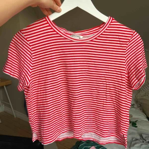 Randig T-shirt  - Röd och vitrandig t-shirt från Monki! Knappt använd, så i fint skick!