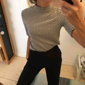 - Turtleneck top i svartvitt mönster. 