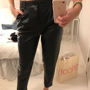 Svarta pösiga skinnbyxor  - Säljer dessa snygga skinnbyxor från Mango. Aldrig använda så prislappen är kvar! Skitsnygg passform som ligger lite lösare runt benen!! Köp för 200 + frakt