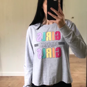 Långärmad tröja från Kappahl strl 146/152 - Grå långärmad tröja från Kappahl. Helt oanvänd. (Prislappen är ej kvar.) Tryck: Girls support girls. 50 kr frakt.