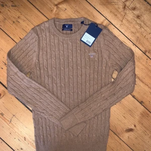 Gant Tröja  - Super snygg beige Gant Tröja som aldrig använts! Det är en cable crew i stretchigt material, super bra skick! 