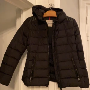Moncler jacka  - Säljer nu denna skitsnygga moncler jacka. Jackans modell är ”Tetras Giubbotto” . Den är självklart äkta! Jackan tycker jag är väldigt cool med tanke på att den är figursydd som man kan se i ryggen. På varje axel är det även en läderpatch som jag tycker gör mycket av jackan!! Det finns så mycket snygga detaljer på denna jacka vilket jag älskar! Säljes pga att jag tyvärr inte får så mycket användning av den. Den är i otroligt gott skick!! Kontakta mig för fler bilder eller information. Köparen står för frakten om det inte är möjligt för köparen att mötas upp i Stockholmsområdet💕 Nypris ca 11 000