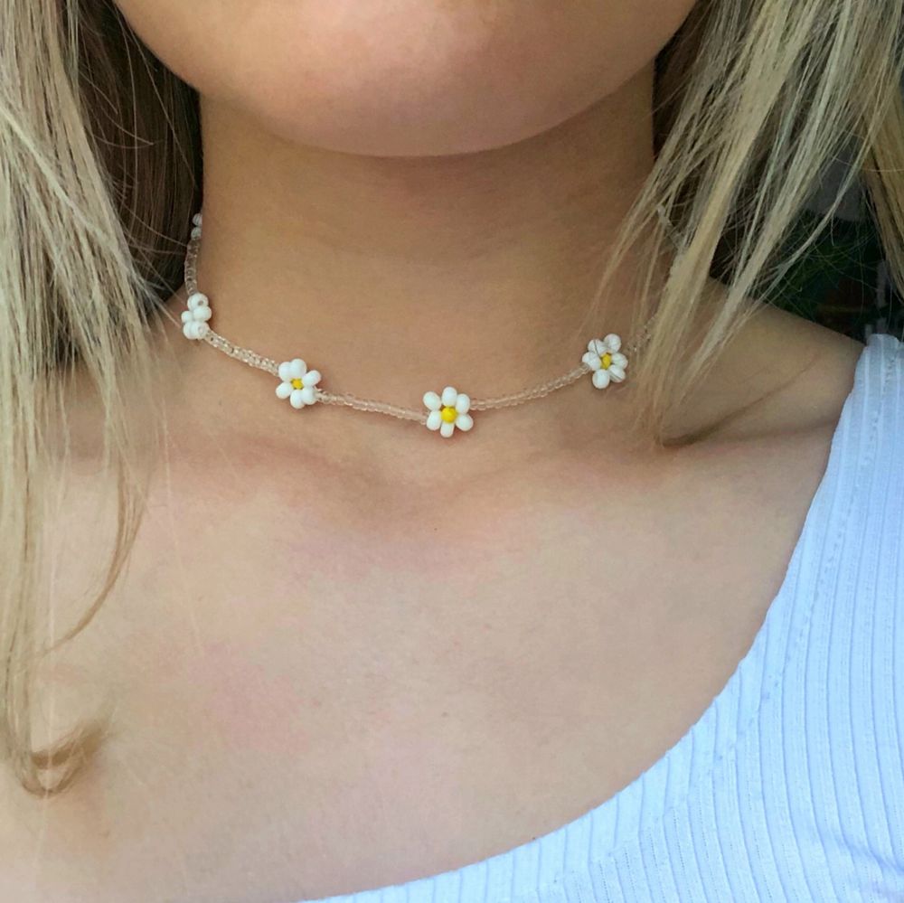 Ett pärlhalsband med vita blommor. Super fint till sommaren! Bra kvalitet och töjbar tråd. Skriv om du vill att jag ska göra halsbandet kortare/längre. 11 kr frakt☀️💕☀️💕. Accessoarer.