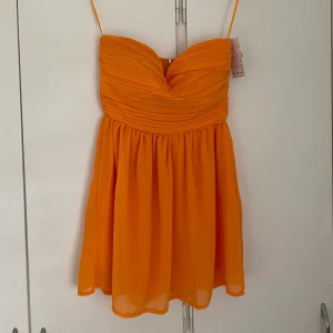 Orange klänning - Helt oanvänd bandeauklänning!! Bara att höra av sig vid frågor och funderingar❤️