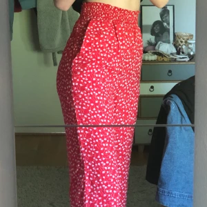 Sommriga byxor - Röda byxor med ljusrosa/vita blommor. Tunt och luftigt tyg men inte genomskinligt vad jag upplevt. Aldrig använda, prislapp kvar. Stolek XS men är stretchiga så passar även S. Köparen står för frakten!🌸