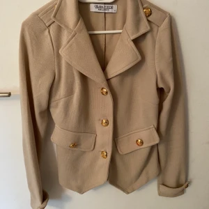Snygg Blazer/kofta  - Beige ”kofta/blazer med Guldiga detaljer! Använd 2-3 gånger säljer pga den är lite för stor för mig. 