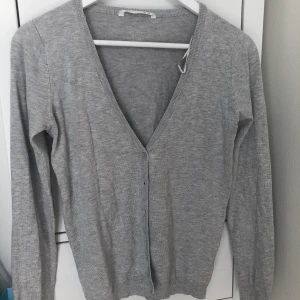 Ljusgrå kofta - Ny kofta som aldrig kommer till användning. 