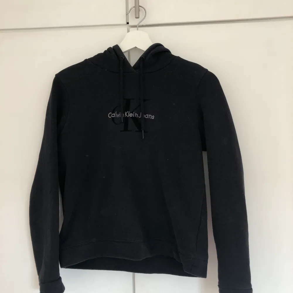 Svart/grå Calvin Klein hoodie i mycket bra skick, nästan helt oanvänd, anledning till att jag säljer den är att jag inte kan ha den längre, den har hängt i min garderob så har jag växt ur den, ca 5 månader gammal, Budgivningen så skriv era bud. Tröjor & Koftor.
