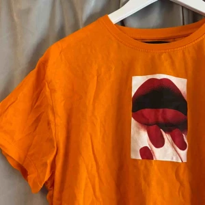  - Pris kan diskuteras!  Orange t-shirt med tryck!