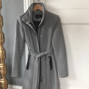 Höstkappa - Grå kappa från Veromoda med knyte i midjan samt dragkedja. Storlek XS